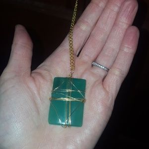 Wire wrapped green stone necklace on gold chain.